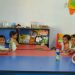 Pre-schooled Kids Sitting Around The Table With Their Teacher To Learn Emotions.