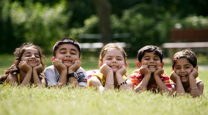 Smiling Kids Lying On The Floor In Outdoor.