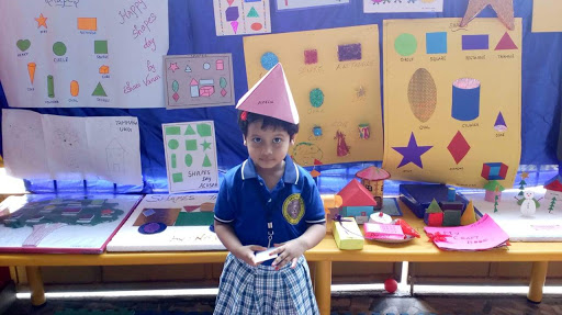 A Cute Little Girl Standing Infront Of The DIY Chart Activities.