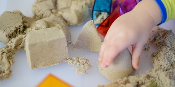 A Kid Playing With Kinetic Sand.