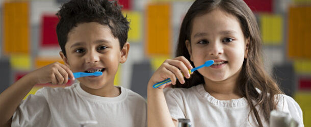 Two Cute Happy Kids Brushing Their Teeth Infront Of Mirror Representing The Healthy Teeth Concept.