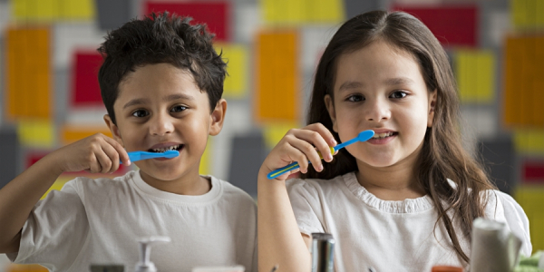 Two Cute Happy Kids Brushing Their Teeth Infront Of Mirror Representing The Healthy Teeth Concept.